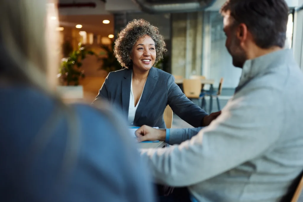 Happy multiracial businesswoman communicating with her colleagues during a meeting in the office.