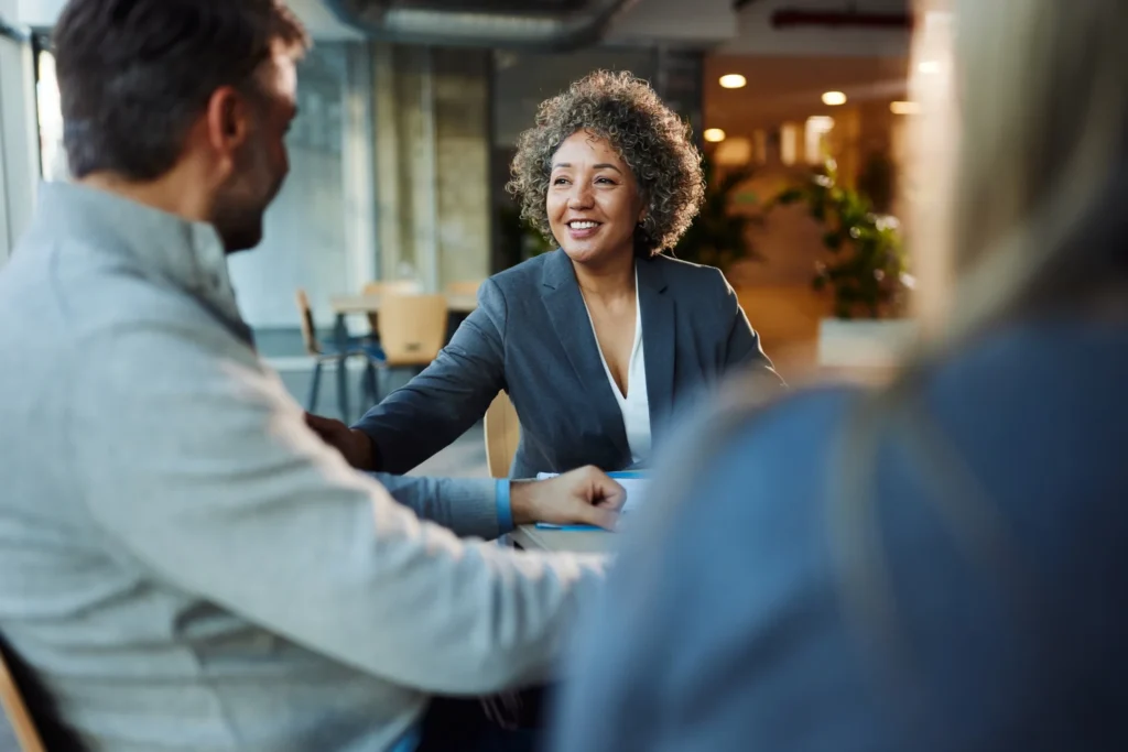 Happy multiracial businesswoman communicating with her colleagues during a meeting in the office.